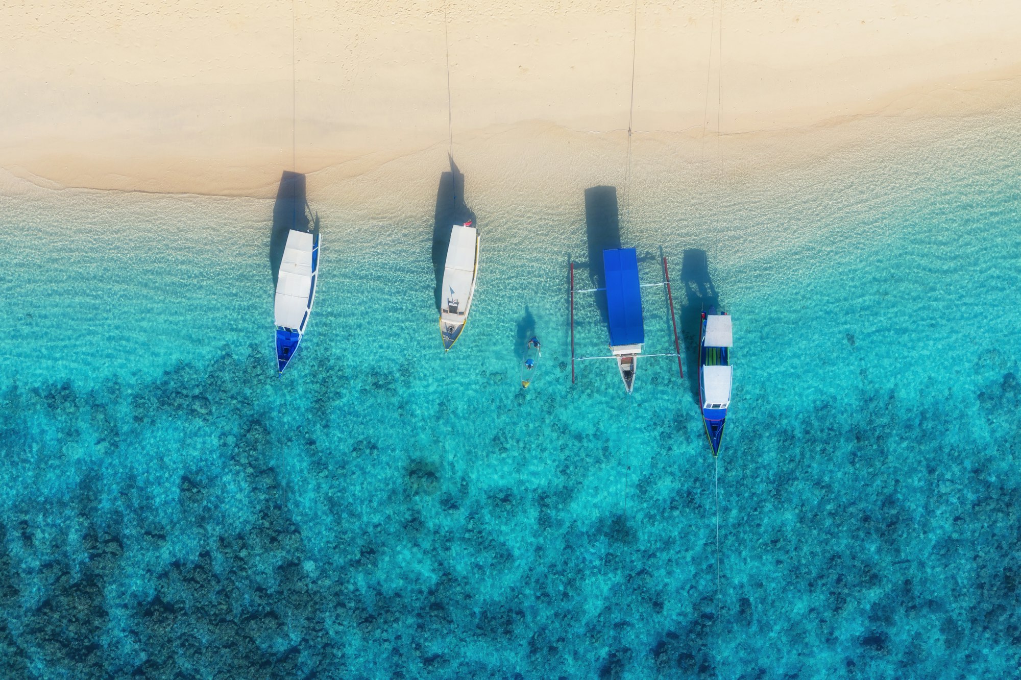 Boats near the beach. Blue water background from top view. Summer seascape